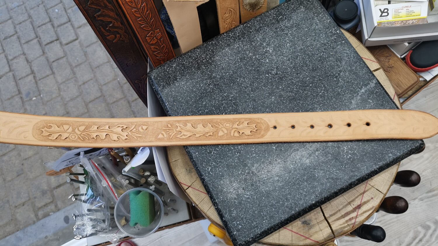 Curea personalizată din piele, cu inițiale gravate pe piele naturală.